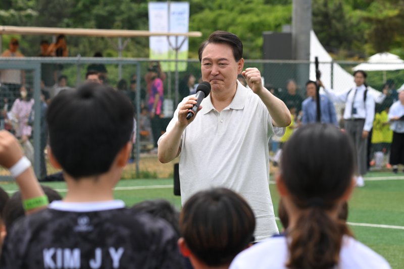 윤석열 대통령이 휴일인 14일 서울 용산 어린이정원 내 축구장에서 대통령실 초청 전국 유소년 축구대회에 참가한 어린이 선수들을 격려하고 있다. [대통령실 제공] 연합뉴스