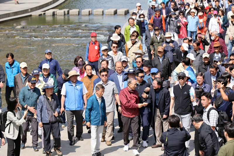 이명박 전 대통령이 15일 서울 청계천에서 옛 참모들과 함께 산책하고 있다. 사진=서동일 기자