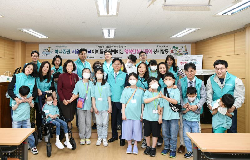 사진설명: 강성묵 하나증권 대표이사(가운데)와 하나증권 임직원, 국립서울맹학교 학생 등이 봄나들이 봉사활동 행사에 참여해 기념촬영하고 있다.