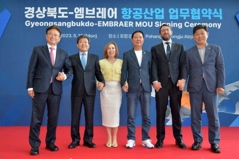 이철우 경북지사와 홈즈 엠브레어 총괄 부사장, 마시어 도너 주한 브라질 대사 등 내빈들이 15일 경북 포항경주공항에서 열린 '항공산업 협력 업무협약식을 마친 후 기념촬영을 하고 있다. 이날 업무협약식을 마친 이철우 지사와 마시아 도너 주한 브리질 대사와 내빈 등은 엠브레어의 주력 제트여객기인 E190-E2타고 울릉도까지 약 80분간 선회비행을 했다.왼쪽부터 이철우 경북지사, 남한권 울릉군수, 마시아 도너 주한 브라질 대사. 남진복 경북도의원(울릉군), 홈즈 엠브레어 총괄 부사장, 박용선 경북도의회부의장.2023.5.15/뉴스1 ⓒ 