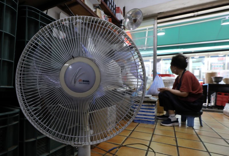정부가 에너지요금 현실화에 드라이브를 걸면서 서민가계의 전기·가스요금 월평균 부담액이 크게 늘어난 16일 서울 시내 전통시장에서 한 상인이 장사를 준비하고 있다. 뉴스1