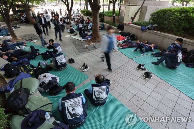 지난 5월 17일 오전 출근시간대 시민들이 서울 중구 청계광장에서 전날 밤 총파업 결의대회 후 노숙하고 있는 민주노총 건설노조원들을 지나치고 있다. /사진=연합뉴스