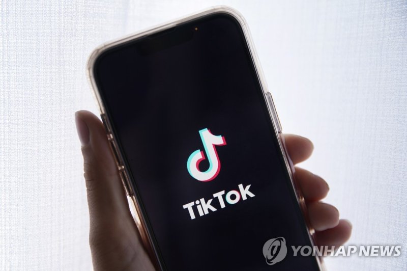 틱톡 epa10635388 In this photo illustration a person holds up a cell phone with the TikTok logo displayed in Los Angeles, California, USA, 17 May 2023. Govenor Greg Gianforte of Montana signed a measure that bans the TikTok app in the state. EPA/CAROLINE BREHMAN