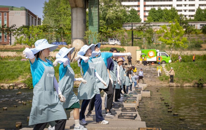 코웨이 임직원들이 지난 17일 안양천에서 열린 'EM흙공 던지기' 행사에 참여하고 있다. 코웨이 제공