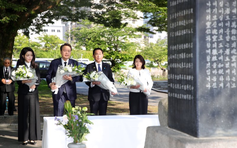 주요 7개국(G7) 정상회의 참관국 자격으로 일본을 방문 중인 윤석열 대통령과 부인 김건희 여사, 기시다 후미오 일본 총리와 부인 기시다 유코 여사가 21일 히로시마 평화기념공원 내 한국인 원폭 희생자 위령비에 참배한 뒤 헌화하고 있다. 연합뉴스