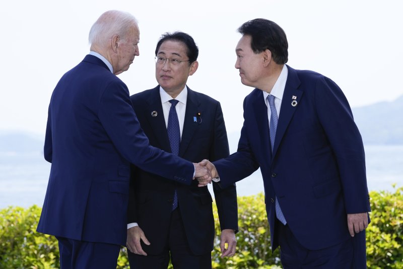 윤석열 대통령과 조 바이든 미국 대통령(왼쪽)이 21일 일본 히로시마에서 주요 7개국(G7) 정상회의를 계기로 열린 한·미·일 정상회담을 앞두고 기시다 후미오 일본 총리(가운데)가 지켜보는 가운데 악수하고 있다. 연합뉴스