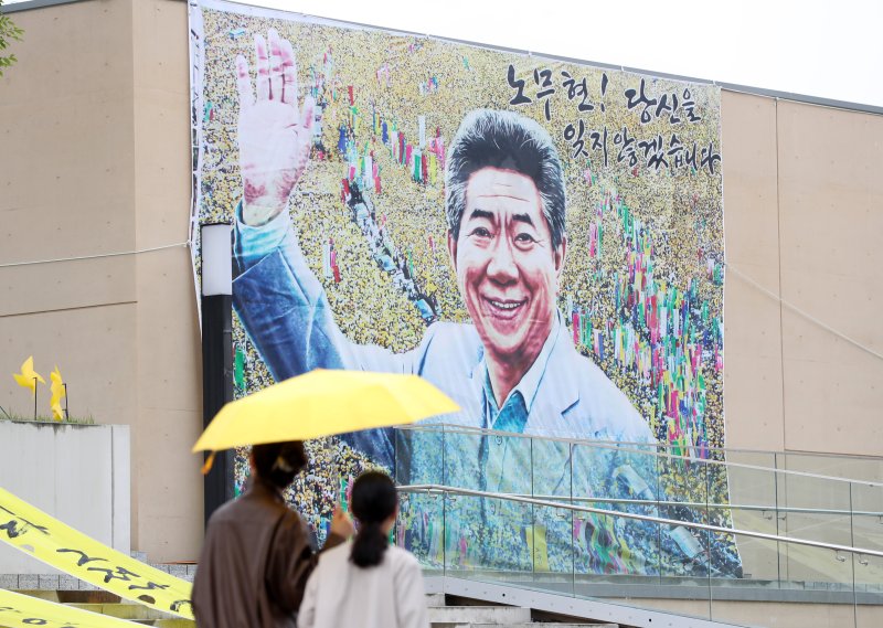 고 노무현 전 대통령 서거 14주기 추도식을 하루 앞둔 22일 오후 경남 김해 봉하마을에서 노란 우산을 쓴 시민들이 깨어있는 시민문화체험전시관 앞을 지나가고 있다. 2023.5.22/뉴스1 ⓒ News1 윤일지 기자 /사진=뉴스1