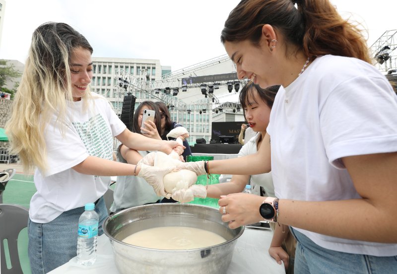 [서울=뉴시스] 김진아 기자 = 24일 서울 동대문구 경희대학교에서 열린 대동제 축제에 참여하는 외국인 유학생 등 학생들이 우리나라 전통주 만들기 체험을 하고 있다. 2023.05.24. bluesoda@newsis.com