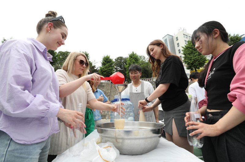 [서울=뉴시스] 김진아 기자 = 24일 서울 동대문구 경희대학교에서 열린 대동제 축제에 참여하는 외국인 유학생 등 학생들이 우리나라 전통주 만들기 체험을 하고 있다.<div id='ad_body3' class='mbad_bottom' ></div> 2023.05.24. bluesoda@newsis.com