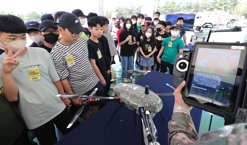 25일 오전 대구 육군 제2작전사 대연병장에서 열린 '제1회 2작전사령관배 드론봇 전투경연대회'를 찾은 학생들이 드론 관련 설명을 듣고 있다. 이번 대회는 총상금 1천만원으로 드론 축구, 드론 레이싱, 드론 챌린지 등 다양한 종목에서 군인과 대학 및 일반부 등 13개 팀 130여 명이 참가했다. 사진=연합뉴스