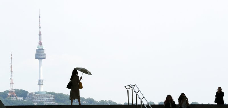 오후부터 내륙을 중심으로 소나기 예보가 내려진 26일 서울 용산구 국립중앙박물관에서 양산을 편 한 시민이 이동하고 있다 . 2023.5.26/뉴스1 ⓒ News1 이동해 기자