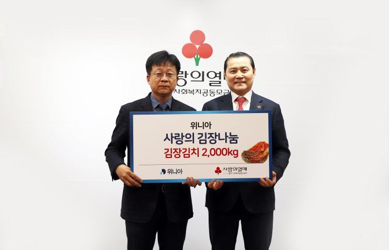 박상덕 위니아 광주공장장(왼쪽)이 지난해 11월 10일 광주사회복지공동모금회에 '건강담은 김치' 2000㎏을 전달한 뒤 김동기 광주사랑의열매 아너 소사이어티 대표와 기념촬영을 하고 있다. 위니아 제공