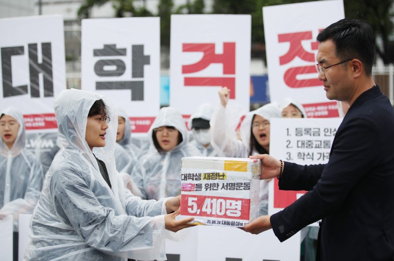 [서울=뉴시스] 김진아 기자 = 전국대학학생회네트워크가 28일 서울 용산구 대통령 집무실 앞에서 열린 '2023 대학생 3대 문제 해결을 위한 공동행동 : 등록금·생활비·구조조정, 대학생 재정난 해결을 위한 서명 전달 기자회견'에서 서명서를 대통령실 관계자에게 전달하고 있다. 2023.05.28. bluesoda@newsis.com