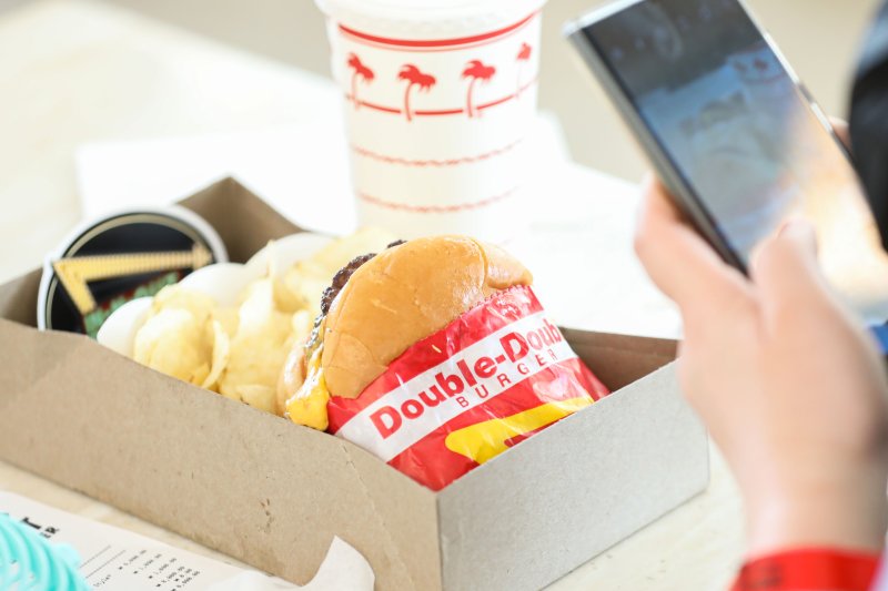 [서울=뉴시스] 권창회 기자 = 31일 오전 서울 강남구 인앤아웃 팝업스토어에서 시민이 버거를 찍고 있다. 2023.05.31. kch0523@newsis.com