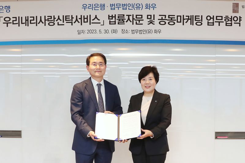 우리은행이 지난 5월 30일 서울 강남구 소재 법무법인(유) 화우와 우리내리사랑 신탁서비스 공동마케팅 업무협약을 체결했다. 송현주 우리은행 자산관리그룹장(오른쪽)과 법무법인(유) 화우 이명수 대표 변호사가 기념촬영을 하고 있다. 우리은행제공