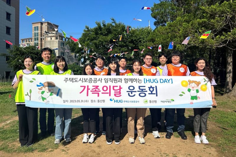 지난달 31일 부산 수영구의 아동복지시설 '동산원'에서 진행된 '1사 1허그결연-HUG 봄 운동회'에서 HUG 임직원들이 기념촬영을 하고 있다. HUG 제공