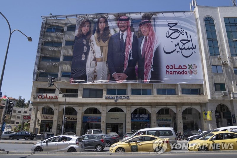 요르단 왕세자 결혼 A poster with pictures of, from right, King Abdullah II, Crown Prince Hussein, Saudi architect Rajwa Alseif and Queen Rania, is hanged at the front of a building in the capital Amman, Jordan, Wednesday, May 31, 2023. Crown Prince Hussein and Saudi architect Rajwa Alseif are to be married 