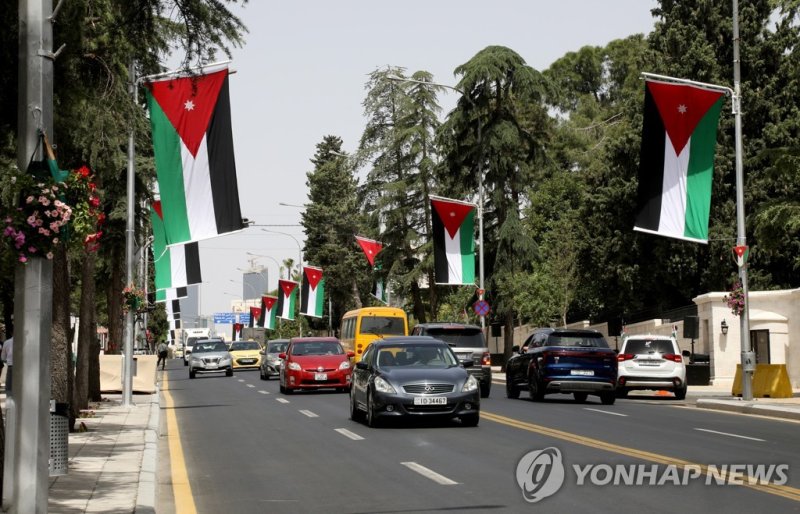 요르단 왕세자 결혼식 Cars ride a street decorated with Jordanian flags on the day of the royal wedding of Jordan's Crown Prince Hussein and Rajwa Al Saif, in Amman, Jordan, June 1, 2023. REUTERS/Alaa Al Sukhni