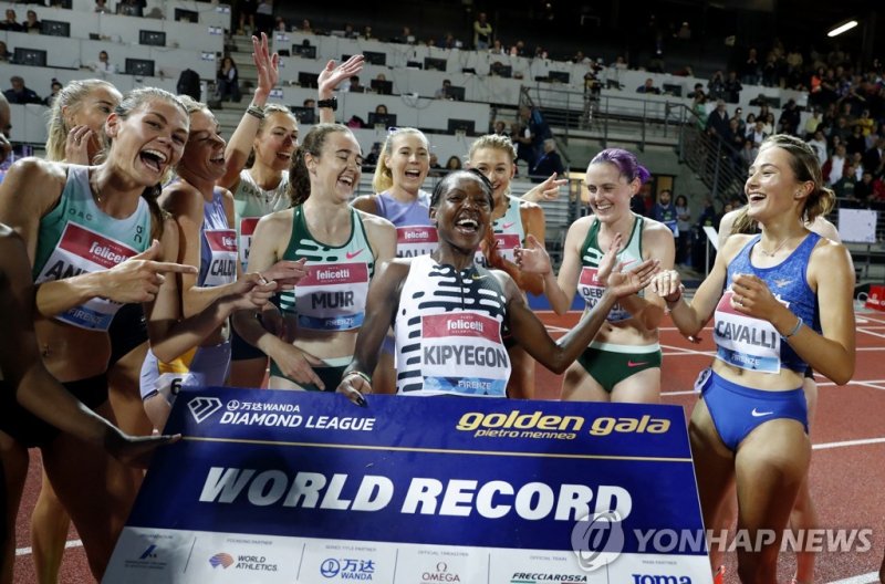 키프예곤, 여자 1,500ｍ 세계신 Athletics - Diamond League - Pietro Mennea Golden Gala - Stadio Luigi Ridolfi, Florence, Italy - June 2, 2023 Kenya's Faith Kipyegon holds her new world record sign as she celebrates winning the women's 1500m final with athletes REUTERS/Remo Casilli