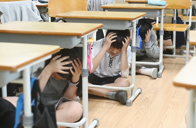 [수원=뉴시스] 김종택 기자 = 강원도 동해시 북동쪽 59km 해역에서 규모 4.5의 지진이 발생한 지난달 15일 경기도 수원시 권선구 칠보중학교에서 학생들이 지진 대피 교육을 받고 있다. 이날 정부는 지진 위기 경보를 관심에서 주의 단계로 상향 조정했다. 2023.05.15. jtk@newsis.com