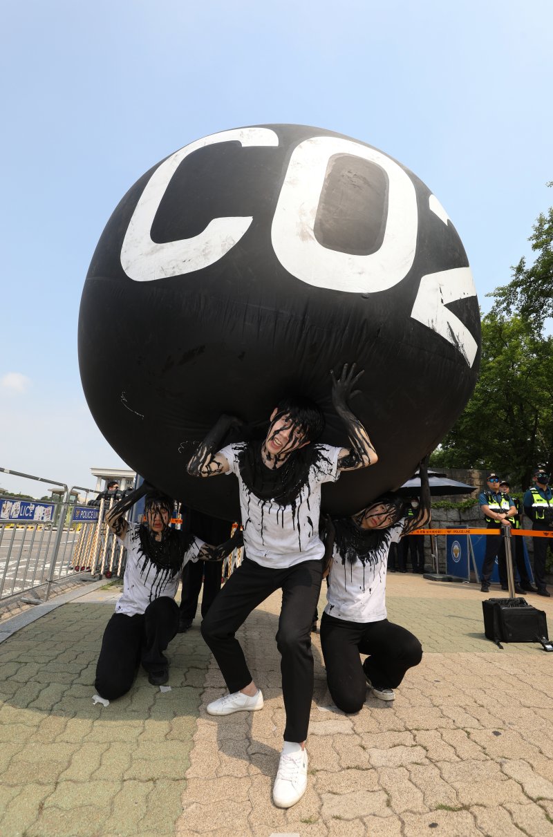 그린피스 회원들이 세계 환경의 날인 5일 서울 여의도 국회 앞에서 기후위기 대응을 촉구하는 '탄소(CO2)의 짐' 퍼포먼스를 하고 있다. 2023.6.5/뉴스1 ⓒ News1 신웅수 기자