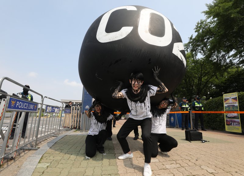 그린피스 회원들이 세계 환경의 날인 5일 서울 여의도 국회 앞에서 기후위기 대응을 촉구하는 '탄소(CO2)의 짐' 퍼포먼스를 하고 있다. 2023.6.5/뉴스1 ⓒ News1 신웅수 기자