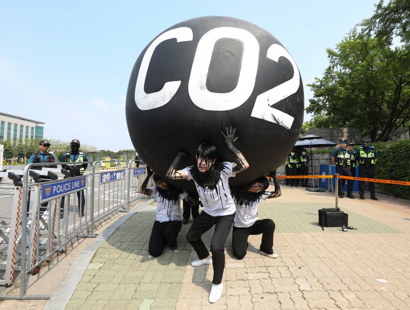 그린피스 회원들이 세계 환경의 날인 5일 서울 여의도 국회 앞에서 기후위기 대응을 촉구하는 '탄소(CO2)의 짐' 퍼포먼스를 하고 있다. 2023.6.5/뉴스1 ⓒ News1 신웅수 기자
