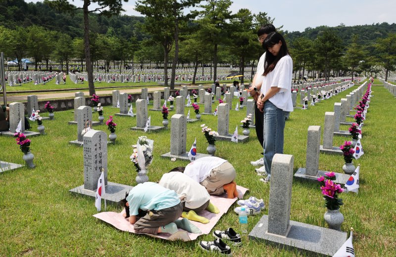 현충일인 지난해 6월 6일 서울 동작구 국립묘지에서 참배객들이 가족 묘소를 참배하고 있다. 사진=연합뉴스