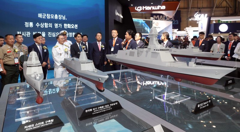 한화오션은 박빙의 점수차로 HD현대중공업을 제치고 8000억원대 규모의 배치3 호위함 5,6번함 건조 사업을 수주했다. 사진은 'MADEX 2023'의 한화오션 부스에서 관람객들이 차기 구축함 모형을 살펴보는 모습. 뉴시스