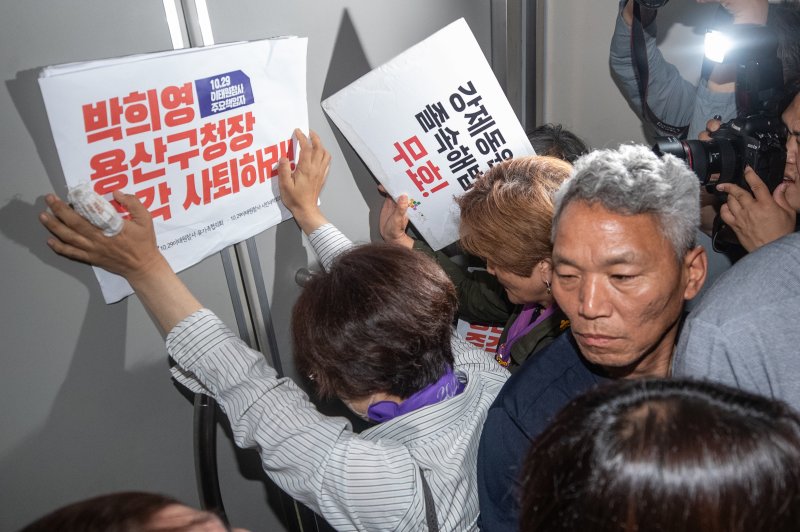 이태원 참사 유가족들이 8일 오전 서울 용산구청에서 이태원 참사에 부실하게 대응한 혐의로 기소된 박희영 용산구청장 출근을 저지하기 위해 손피켓을 들고 항의하고 있다. 2023.6.8/뉴스1 ⓒ News1 이재명 기자