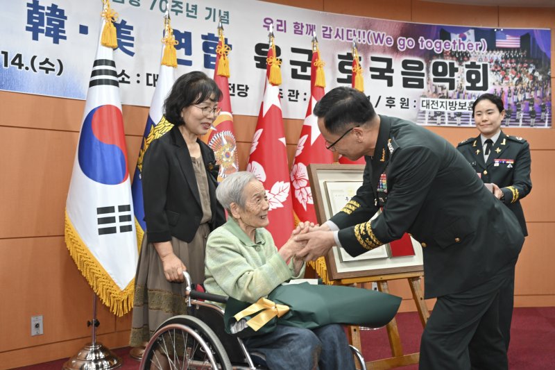 14일 대전예술의전당에서 열린 '한미 연합 육군 호국음악회' 행사의 일환으로 박정환 육군참모총장이 6.25참전용사 故 김송학 하사의 유가족에게 화랑무공훈장을 전달한 후 기념사진을 촬영하고 있다.(육군 제공)