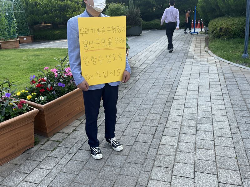 15일 오전 8시 30분께 서울 용산구청 진입로에서 주민 A씨가 "우리가 뽑은 구청장이 용산구민을 위해 일할수있도록 해주십시오"라고 적힌 피켓을 들고 서 있다./ 사진= 주원규 기자