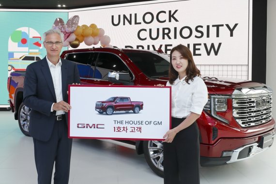 한국GM의 로베르토 렘펠 사장이 지난 14일 서울 강남구 도산대 소재 GM의 통합 브랜드 전시장인 '더 하우스 오브 지엠'에서 차량인도식을 열어, 이곳에서 1호로 프리미엄 픽업인 GMC 시에라 드날리를 구입한 변상은씨(41)에게 감사인사를 전하며 기념촬영을 하고 있다. 한국GM 제공