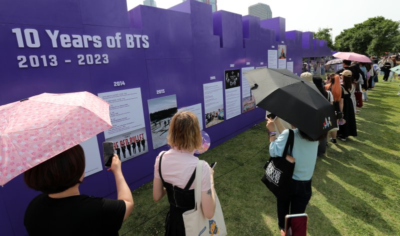 [서울=뉴시스] 조성우 기자 = 그룹 방탄소년단(BTS) 데뷔 10주년 기념 '2023 BTS 페스타'가 열린 17일 오후 서울 영등포구 여의도 한강공원에서 팬들이 BTS 10주년 기념 전시를 관람하고 있다. 2023.06.17. xconfind@newsis.com