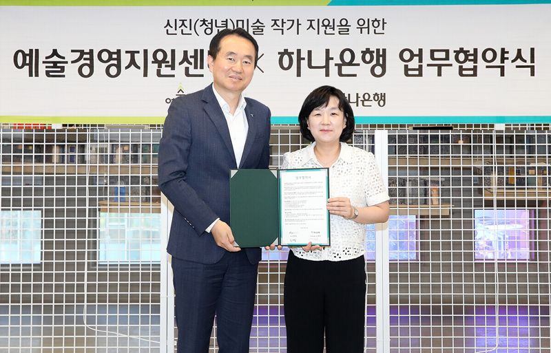 김영훈 하나은행 자산관리그룹장(왼쪽)과 김승연 예술경영지원센터 본부장이 지난 16일 서울시 을지로4가에 위치한 하나은행의 개방형 수장고 '하트원'에서 신진(청년) 미술 작가 발굴 및 작품 판로 지원을 위한 전략적 업무협약(MOU)을 체결하고 함께 기념 촬영을 하고 있다. 하나은행 제공