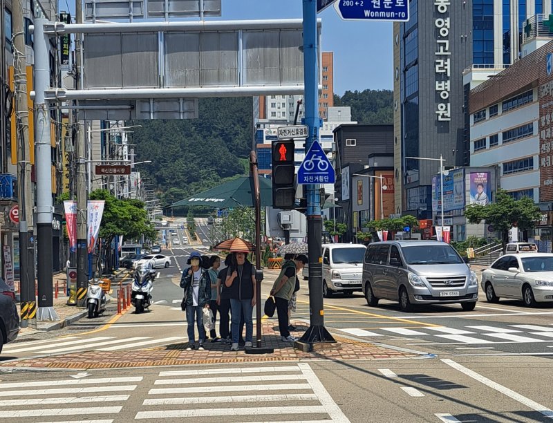 19일 낮 경남 통영시 무전동 무전사거리 횡단보도 앞 인도에 설치된 그늘막 아래에서 시민들이 햇빛을 피하고 있다. 2023.6.19. ⓒ 뉴스1 강미영 기자