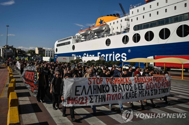 그리스 항구에서 열린 난민 차단 반대 시위 Protesters carry a banner that reads "Stop pushbacks, abolish Frontex, the Greek state and EU murder' during a protest march to Frontex and Hellenic Coastguard headquarters in the port of Piraeus near Athens, on June 18, 2023, following the deadly shipwreck which costed lives