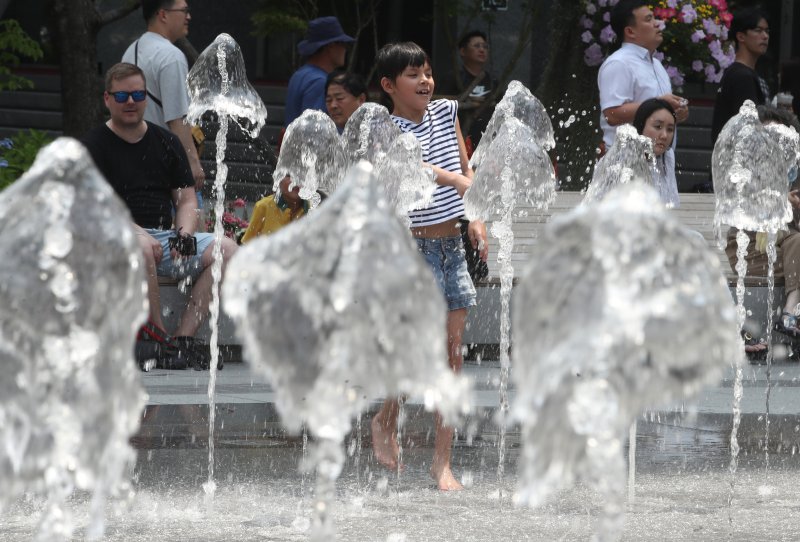 30도가 넘어 폭염특보가 발효된 지난 19일 서울 종로구 광화문 광장에 나들이 나선 어린이가 거리분수에서 더위를 식히고 있다. 뉴시스