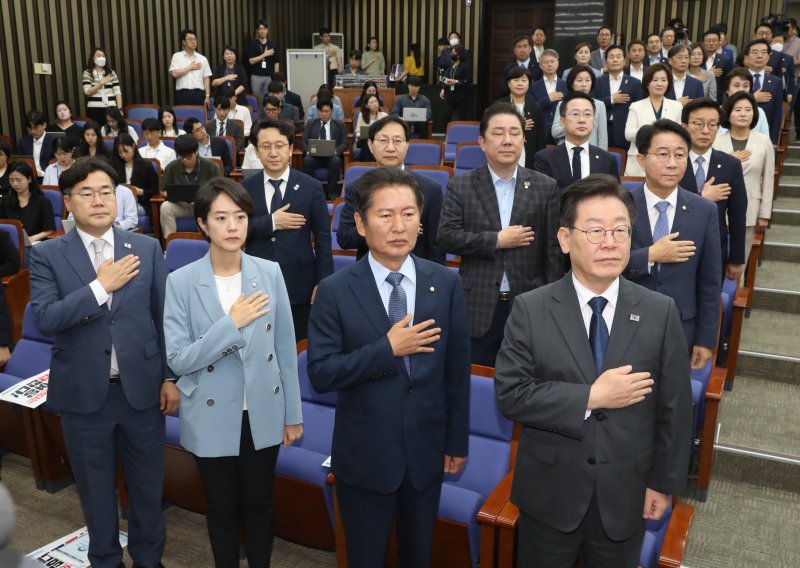 이재명 더불어민주당 대표 등이 21일 오전 국회에서 열린 정책 의원총회에서 국기에 경례를 하고 있다. 뉴스1