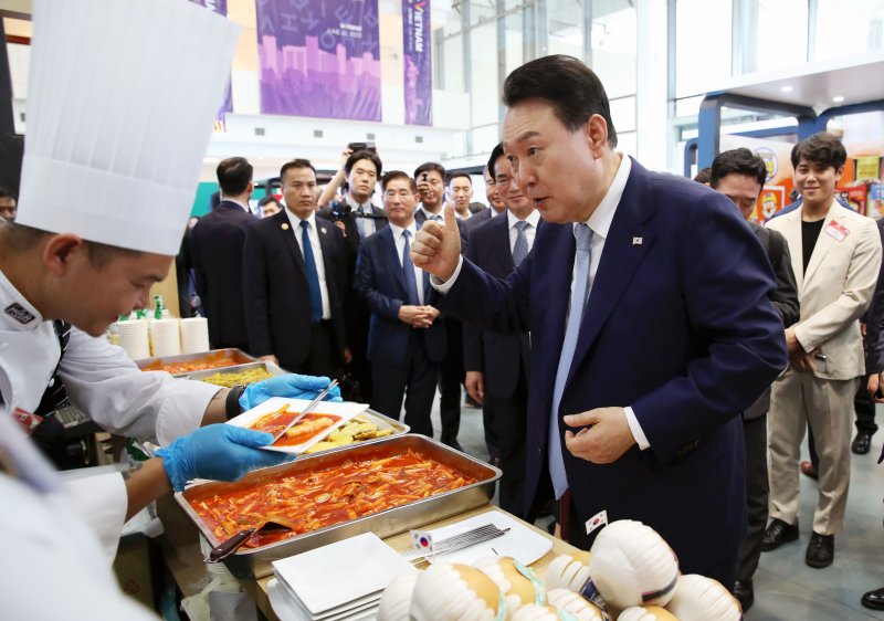 [하노이=뉴시스] 전신 기자 = 베트남을 국빈 방문한 윤석열 대통령이 22일(현지시간) 하노이 국가컨벤션센터에서 열린 한-베트남 파트너십 박람회에서 K-Food 행사장을 찾아 떡볶이를 시식한 뒤 엄지를 치켜 세우고 있다. 2023.06.22. photo1006@newsis.com <저작권자ⓒ 공감언론 뉴시스통신사. 무단전재-재배포 금지.> /사진=뉴시스화상