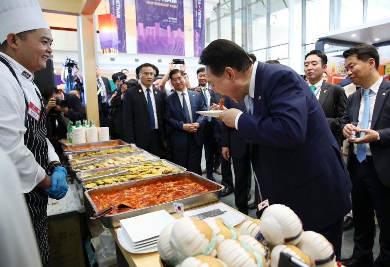 [하노이=뉴시스] 전신 기자 = 베트남을 국빈 방문한 윤석열 대통령이 22일(현지시간) 하노이 국가컨벤션센터에서 열린 한-베트남 파트너십 박람회에서 K-Food 행사장을 찾아 떡볶이를 시식하고 있다. 2023.06.22. photo1006@newsis.com <저작권자ⓒ 공감언론 뉴시스통신사. 무단전재-재배포 금지.> /사진=뉴시스화상