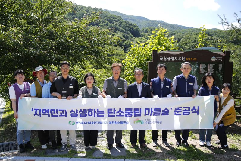 지난 27일 경북 예천군 효자면 산림치유원 문필지구 음이온치유정원 일대에서 열린 ‘탄소중립 마을숲’ 개장 행사에서 국립산림치유원 관계자 등이 기념촬영을 하고 있다.