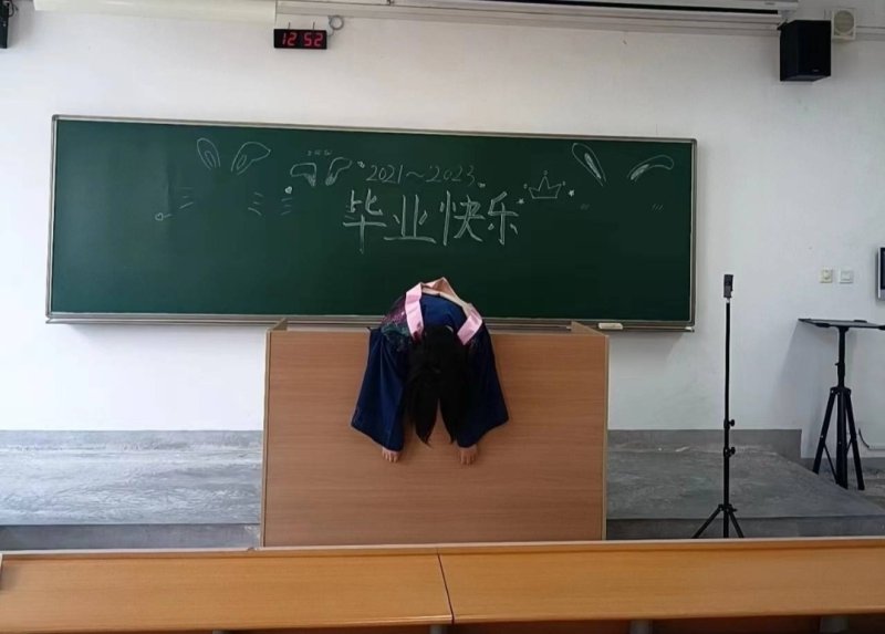한 대학생이 교탁 위에 축 늘어져 있다. 칠판에는 '졸업축하'라는 글이 쓰여 있다 - 웨이보 갈무리