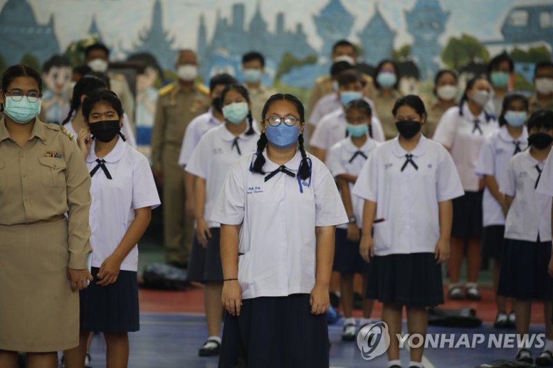 교복 입은 태국 학생들 epa09582771 Students listen to the Thai national anthem on the first day of returning to school in Bangkok, Thailand, 15 November 2021. The Bangkok Metropolitan Administration (BMA) has approved the reopening of schools following an 80 percent vaccination rate amongst secondary school s