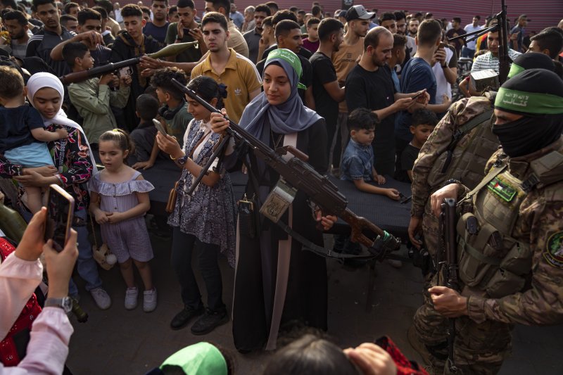 지난 6월 30일 팔레스타인 가자지구에서 열린 무장정파 하마스의 무기 전시회 가운데 현지 관람객이 기관총을 들고 있다.AP뉴시스