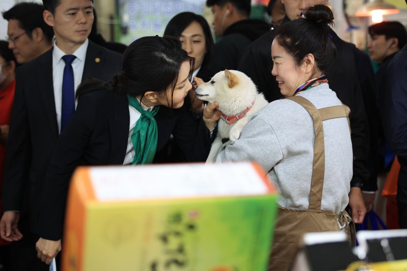 김건희 여사가 지난 4월14일 대전 중구 태평전통시장을 방문해 한 상인이 키우는 유기견 로또와 인사하며 뽀뽀하고 있다. (대통령실 제공) 2023.4.14/뉴스1 ⓒ News1 안은나 기자