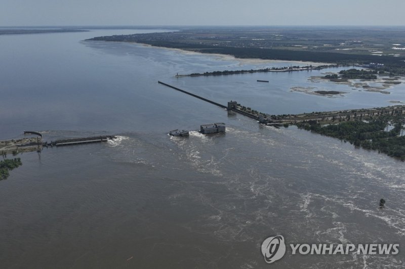 폭발로 붕괴한 우크라이나 헤르손주 카호우카 댐 Water flows over the collapsed Kakhovka Dam in Nova Kakhovka, in Russian-occupied Ukraine, Wednesday, June 7, 2023. Russia had the means, motive and opportunity to bring down a Ukrainian dam that collapsed earlier this month while under Russian control, according to exclusi