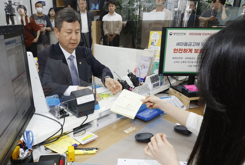 "새마을금고 통장 개설합니다" 새마을금고 '뱅크런' 우려 불식을 위해 한창섭 행정안전부 차관(왼쪽)이 6일 서울 종로구 새마을금고 경희궁지점에서 통장을 직접 개설하고 있다. 뉴시스