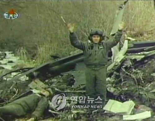 북한 공격으로 추락한 OH-58 헬기 조종사 (서울=연합뉴스) 북한 중앙TV는 지난 1994년 12월 17일 강원도 금강군 이포리 지역 군사분계선을 넘은 미군 OH-58C 정찰용 헬리콥터를 격추시켰던 장면을 내보냈다. 생존한 헬리콥터 조종사(보비 홀 준위)가 벌벌 떨며 손을 들고 있고 그 옆에는 격추 당시 사망한 하일먼 준위의 시신이 보인다./북한/조선중앙TV촬영/ 2005.5.15