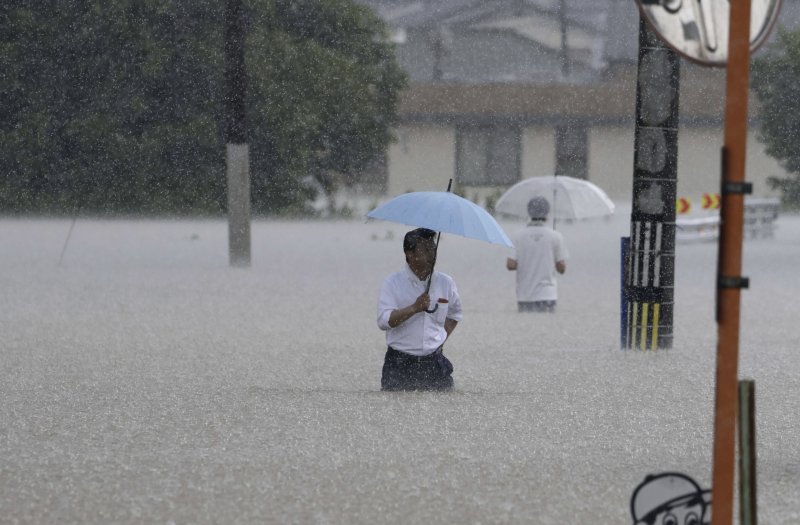 10일 일본 남부 후쿠오카현 구루메에서 주민들이 폭우로 침수된 도로를 힘겹게 지나고 있다. 일본 남서부 지역에 폭우가 쏟아지면서 홍수와 산사태가 발생했으며 일본 기상청은 규슈 남부 일부 지역에 호우경보를 발령했다. 뉴시스